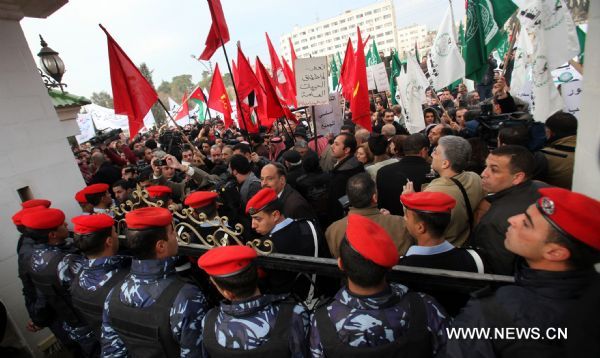 Protestors from opposition parties and labor unions protest outside Jordanian Lower House during an anti-government demonstration in Amman, Jordan, on Jan. 16, 2011. Hundreds of Jordanians on Sunday staged a sit-in, calling for the resignation of the government and protesting rising prices in the country. [Xinhua] 