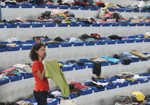 Volunteers distribute relief clothes at a stadium of Teresopolis city of the state of Rio de Janeiro , Brazil, Jan 16, 2011. [Xinhua]