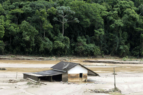 A house is partially submerged in mud after a landslide in Vieira, a mountainous region north of Rio de Janeiro, Brazil, Jan 16, 2011. [China Daily/Agencies]