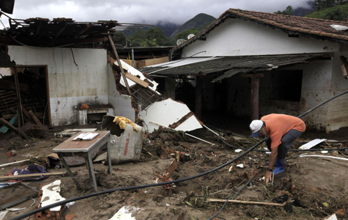  A man cleans his house after a landslide in Vieira, a mountainous region north of Rio de Janeiro, Brazil, Jan 16, 2011. [China Daily/Agencies] 