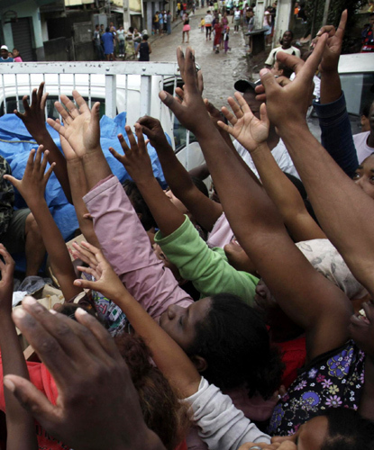 Residents reach for relief supplies following a landslide in their area of Nova Friburgo in the state of Rio de Janeiro, Brazil, Jan 16, 2011. [China Daily/Agencies]