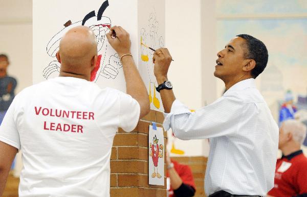 U.S. President Barack Obama (R) paints on the walls with other volunteers as he and his family volunteer in honor of Martin Luther King Jr Day, at Stuart-Hobson Middle School on Capitol Hill in Washington, January 17, 2011. [Xinhua/Reuters] 