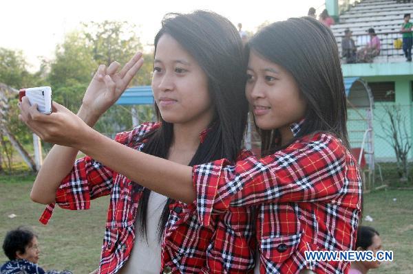 A pair of twin take photo during the first similarity competition for multiple birth siblings in Yangon, Myanmar, on Jan. 16, 2011. The competition attracted a total of 101 pairs of contestants.[Xinhua] 