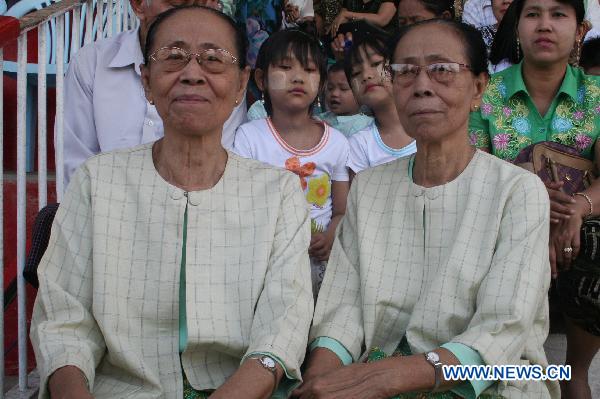 A pair of twin sisters pose during the first similarity competition for multiple birth siblings in Yangon, Myanmar, on Jan. 16, 2011. The competition attracted a total of 101 pairs of contestants.[Xinhua] 