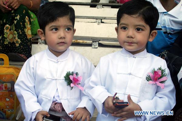 A pair of twin brothers pose during the first similarity competition for multiple birth siblings in Yangon, Myanmar, on Jan. 16, 2011. The competition attracted a total of 101 pairs of contestants.[Xinhua]