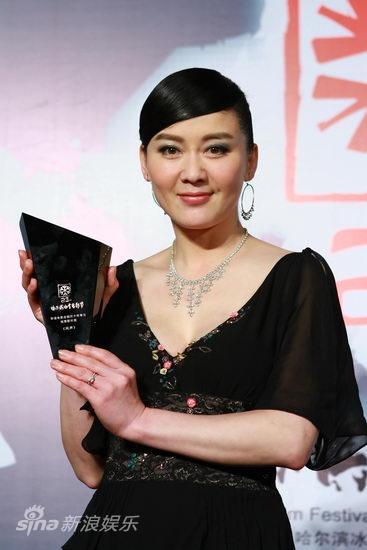 Actress Li Lin accepts the award on Feng Xiaogang's behalf for Feng's film 'Aftershock' at the Harbin Film Festival on January 16, 2011.