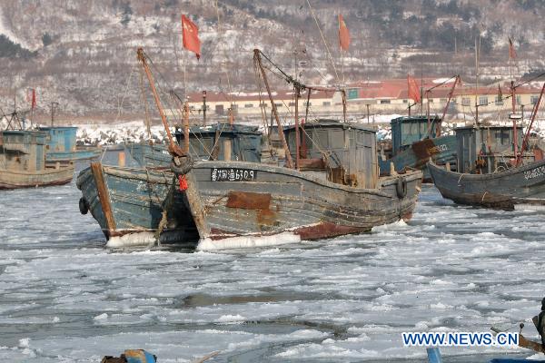 Fishing boats are seen stranded in the iced surface at Zhifu Island in eastern China's Shandong Province, Jan. 17, 2011. The thickness of the freezing ice has amounted to 15 to 20 centimeters due to continuous cold waves while most offshore activities were forced to be halted. 