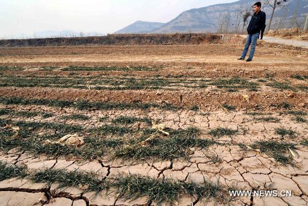 A man stands on the dried field in Duandian village, Shuangquan Township of Changqing, Jinan, capital of east China&apos;s Shandong Province, Jan. 18, 2011. A severe drought hit Shandong Province, covering an area of more than 20,106 square kilometers. Facing shortage of water, local government planned to invest 275 million yuan (about 41.7 million US dollars) to build a set of irrigation projects. 