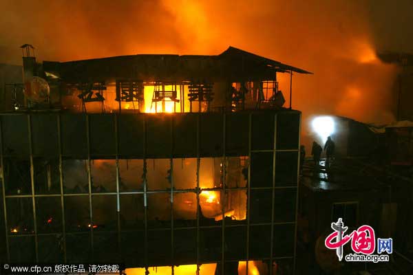 Flames and smoke billow out of a building in Wuhan, Hubei province, Jan 18, 2011. [CFP]