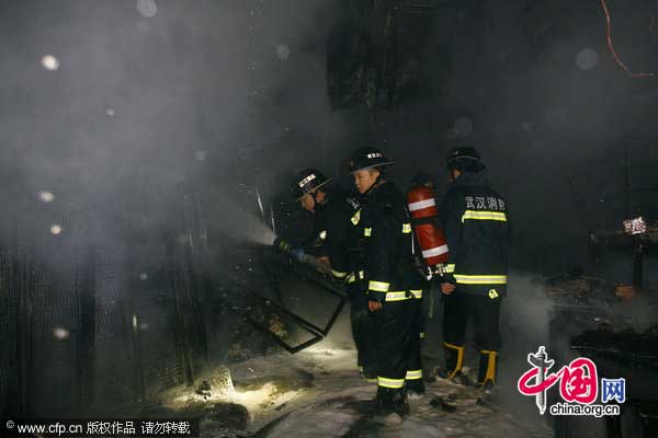 Firefighters work at the site of a fire in Wuhan, Hubei province, Jan 18, 2011. [CFP]