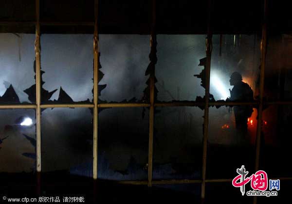 A firefighter works at the site of a fire in Wuhan, Hubei province, Jan 18, 2011. [CFP]