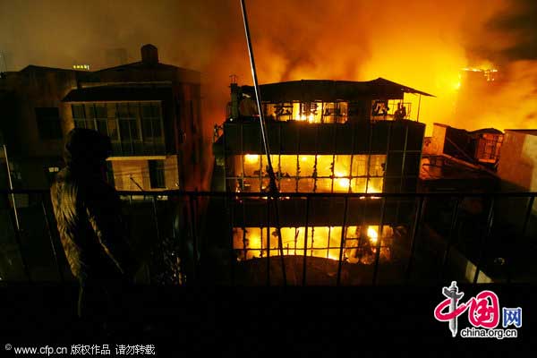 Flames and smoke billow out of a building in Wuhan, Hubei province, Jan 18, 2011. [CFP]