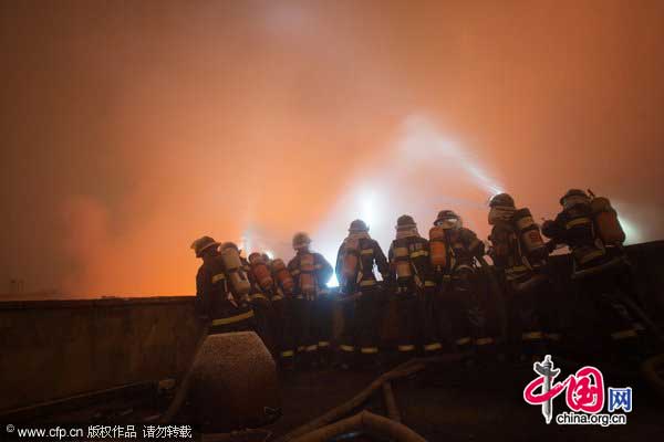 Firefighters work at the site of a fire in Wuhan, Hubei province, Jan 18, 2011. [CFP]