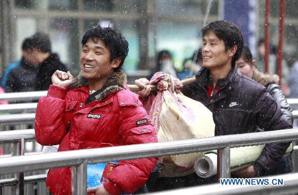 Two migrant workers from Anhui province enter the railway station in East China&apos;s Shanghai, Jan 18, 2011.[Xinhua] 