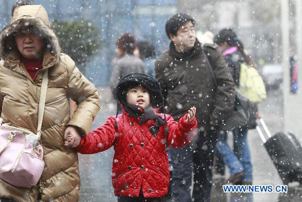 Five-year-old Xin Jie enters the waiting hall of the railway station with her grandmother in East China&apos;s Shanghai, Jan 18, 2011. [Xinhua] 