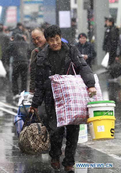 Two passengers walk through the south square of the railway station in East China&apos;s Shanghai, Jan 18, 2011. [Xinhua] 