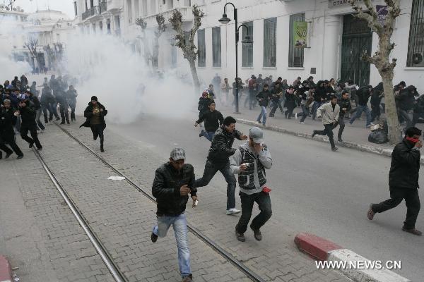 Protestors run away as police use tear gas during a demonstration against Tunisia's ruling Constitutional Democratic Rally party (RCD) in the center of Tunis, Jan. 18. 2011. Tunisian interim president Foued Mebazaa and Prime Minister Mohammed Ghannouchi quit the RCD Tuesday reported official TAP news agency. In the meantime, the RCD announced Tuesday to expel ousted former President Zine El Abidine Ben Ali and six of his close associates from the party. [Nasser Nouri/Xinhua]