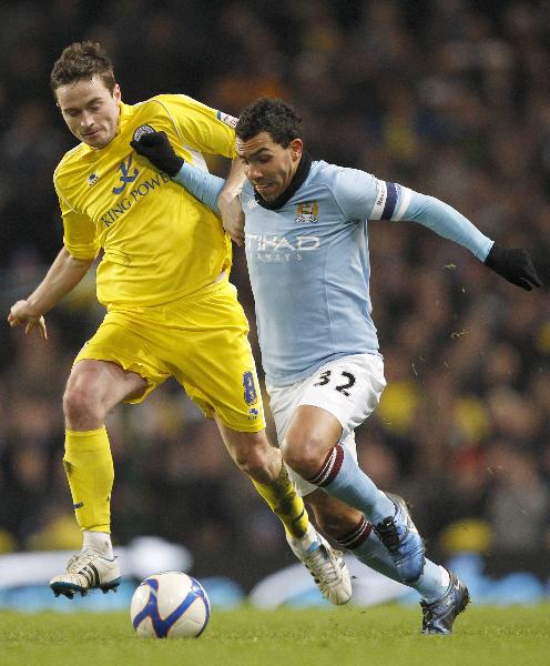 Manchester City's Carlos Tevez (R) fights off Leicester City's Matt Oakley during their FA Cup soccer match at the City of Manchester Stadium in Manchester, northern England, January 18, 2011. (Xinhua/Reuters Photo)