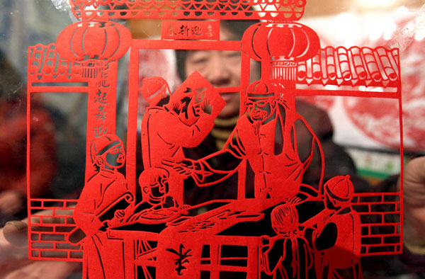 Paper cutting expert Wang Zhenzhu (R) from Yunchen city, North China's Shanxi province shows her creative work, Jan 18, 2011. [Photo/Xinhua] 