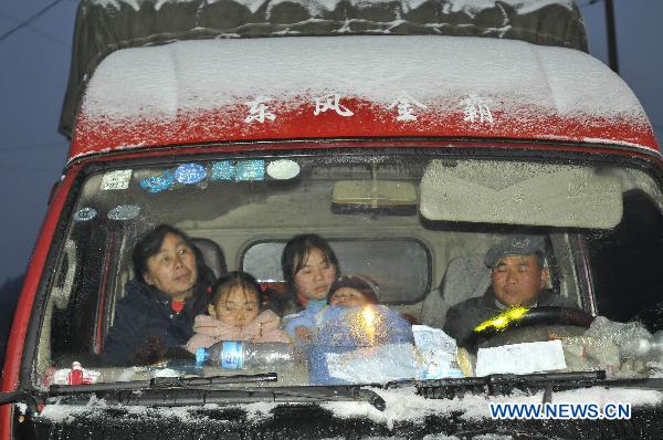Passengers wait in a truck on the frost-stricken No. 308 Provincial Highway for the recovery of traffic in Kaili, southwest China&apos;s Guizhou Province, Jan. 17, 2011. Snow and freezing rain hit the city of Kaili on Monday, trapping more than 2,000 vehicles in congestion. Road administration officials sprinkled salt on the frozen road, with the traffic returning to normal at 10:00 pm. [Xinhua]