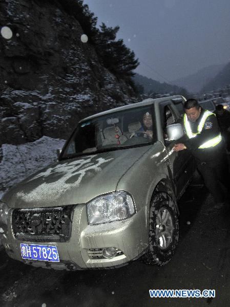 A road administration official offers help to a trapped vehicle on the frozen No. 308 Provincial Highway in Kaili, southwest China&apos;s Guizhou Province, Jan. 17, 2011. Snow and freezing rain hit the city of Kaili on Monday, trapping more than 2,000 vehicles in congestion. 