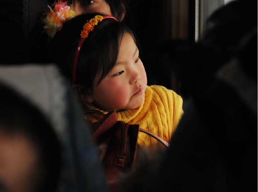 A child waits for the train to depart in Shijiazhuang, capital city of Central China&apos;s Hebei province, Jan 19, 2011.As the Spring Festival approaches, children living in the big cities with their migrant parents face long journeys home as families reunite for the holidays. [Photo/Xinhua]