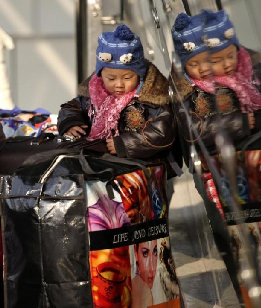 Parents prepare to take their child home at Nanjing railway station in Nanjing, capital city of East China&apos;s Jiangsu province, Jan 9, 2011. [Photo/Xinhua]