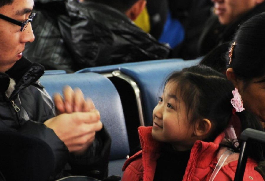 A girl smiles at her father at Changchun railway station in Changchun, capital city of Northeast China&apos;s Jilin province, Jan 18, 2011. [Photo/Xinhua]