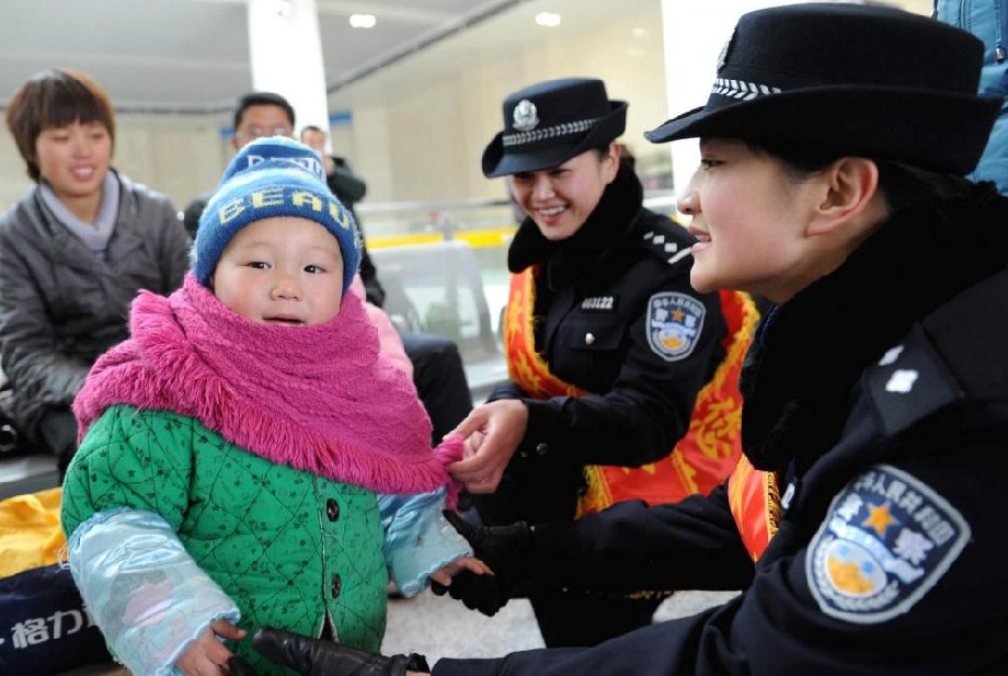 A police officers talks with a child who is waiting to go home in Hefei, Central China&apos;s Anhui province, Jan 19, 2011. [Photo/Xinhua]