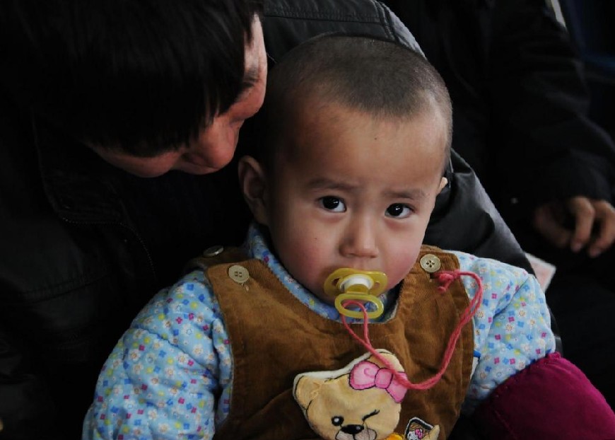 An 18-month-old child and his father wait for their train at Changchun railway station in Changchun, capital city of Northeast China&apos;s Jilin province, Jan 18, 2011. [Photo/Xinhua]