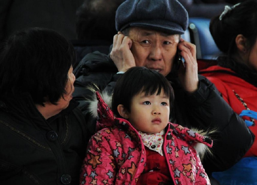 A girl and her grandparents wait to board a train home at Changchun railway station in Changchun, capital city of Northeast China&apos;s Jilin province, Jan 18, 2011. [Photo/Xinhua]