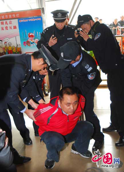 Policemen catch a suspect at Guangzhou South Railway Station on January 18, 2011 in Guangzhou, Guangdong Province of China. One of the suspects hid in a luggage and the other suspect carried the luggage to the train. They want to steal valuables of other passengers after the train running. [Photo/CFP]