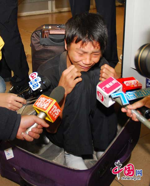 A suspect reacts after being caught at Guangzhou South Railway Station on January 18, 2011 in Guangzhou, Guangdong Province of China. One of the suspects hid in a luggage and the other suspect carried the luggage to the train. They want to steal valuables of other passengers after the train running. [Photo/CFP]