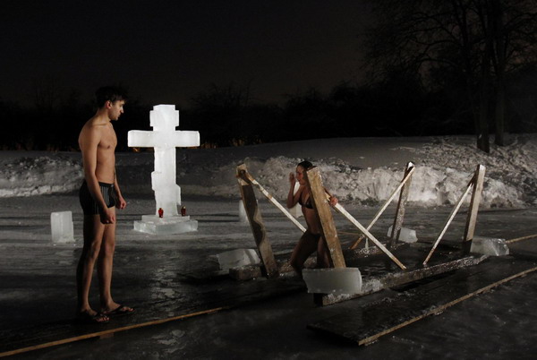 Orthodox Christians immerse themselves in icy waters during an Epiphany day celebration, with air temperature at about minus 16 degrees celsius in Moscow January 19, 2011. Orthodox Christians celebrate the religious holiday of Epiphany according to the Gregorian calendar on January 19. [China Daily/Agencies]