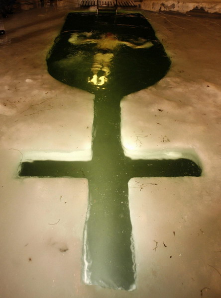 A man dips into the icy waters of Tsnyanskoye reservoir during Epiphany celebrations in Minsk late January 18, 2011. [China Daily/Agencies]