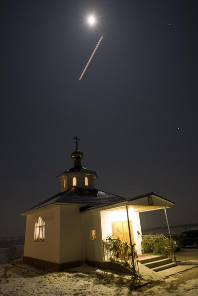 A plane flies above a church during an Epiphany service, some 45 km ( 28 miles) east of Almaty, January 18, 2011. [China Daily/Agencies]