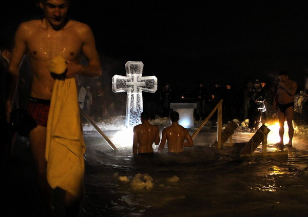 People bathe in the icy waters of a pond during Orthodox Epiphany celebrations in Moscow January 19, 2011. [China Daily/Agencies]