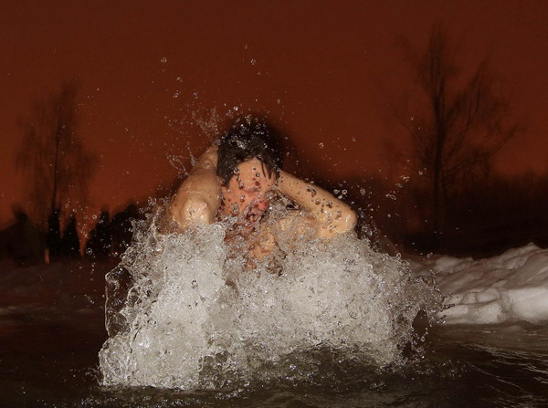 A man bathes in the icy waters of a lake during Epiphany celebrations in Minsk January 18, 2011. Orthodox Christians celebrate the religious holiday of Epiphany according to the Gregorian calendar on January 19. [China Daily/Agencies]