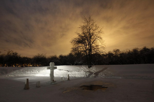 An ice hole for water consecration is seen at a pond during an Orthodox Epiphany celebration, with the air temperature at about minus 16 degrees Celsius in Moscow January 19, 2011. [China Daily/Agencies]