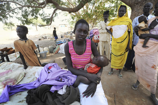 Newly arrived southern Sudanese returnees from Darfur are photographed with their belongings shortly after being dropped off from a bus in Wanjok, near Aweil in Northern Bhar El-Ghazal January 16, 2011. [Xinhua/Reuters]