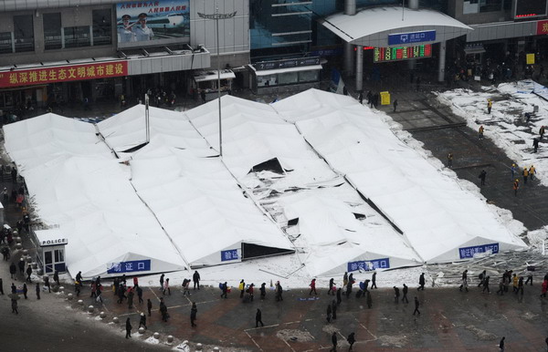 Temporary ticket checking sites are all covered by heavy snow as Guiyang is hit by another snowfall early on Jan 19, 2011.[Photo/Xinhua] 