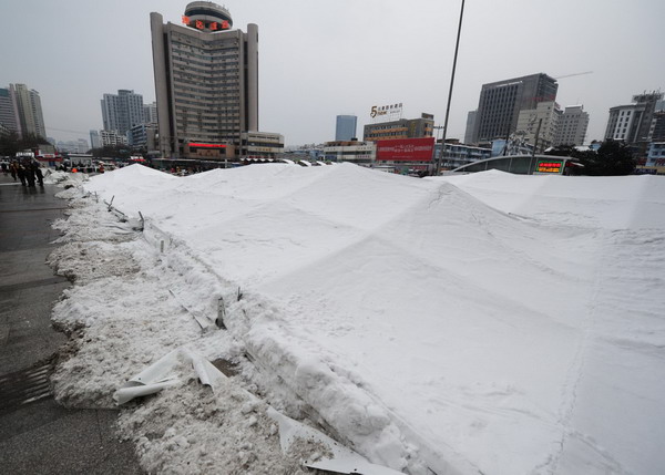 The crushed roof is buried on the ground with a thick covering of snow in Guiyang Railway Station, Guiyang, Southwest China&apos;s Guizhou province on Jan 19, 2011.[Photo/Xinhua]