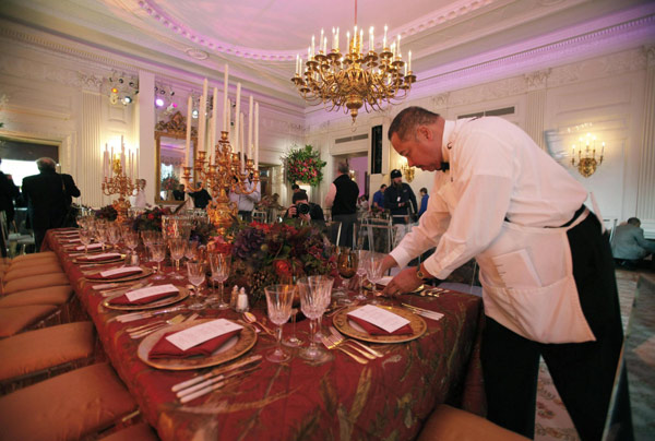 A White House kitchen staffer sets the main table during a press preview of the table settings for the state dinner hosted by US President Barack Obama for President Hu Jintao at the White House in Washington Jan 19, 2011. [China Daily/Agencies] 