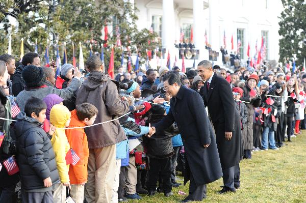 Chinese President Hu Jintao and U.S. President Barack Obama shake hands with crowds at a welcoming ceremony at the South Lawn of the White House in Washington, capital of the United States, Jan. 19, 2011.[Huang Jingwen/Xinhua]