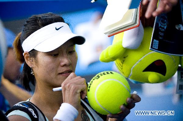 Li Na of China signs on a tennis ball for a fan after the second round of women's single match against Evgeniya Rodina of Russia at the Australian Open tennis tournament in Melbourne, Australia, Jan. 19, 2011. (Xinhua/Chen Duo) 