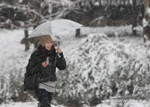 A girl walks in snow in Shanghai, east China, Jan. 20, 2011. Local weather station issued warnings on the possible further snow storm.