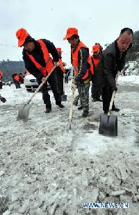Workers clean ice on a road in Yunyan District of Guiyang, capital of China's southwest Guizhou Province, Jan. 19, 2011. Guiyang witnessed its first heavy snowfall in the beginning of this year. 