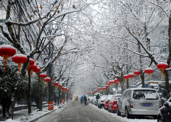 People walk on a snow and ice-covered road in Hangzhou, East China&apos;s Zhejiang province, Jan 20, 2011. Heavy snow and icy rain are continuing to sweep East and South China, disrupting traffic, closing airports, cutting water and power supplies and causing havoc for ordinary Chinese.[Photo/Xinhua]
