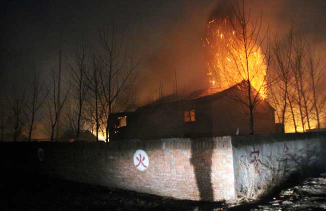 Flames rise from a fireworks plant after an explosion, which left at least 9 people dead and 21 others injured in Laogongtian village, Luohe city, Central China&apos;s Henan province, Jan 19, 2011. The blast ripped through the Yutian Fireworks Plant about 4:50 pm. [Photo/Xinhua]