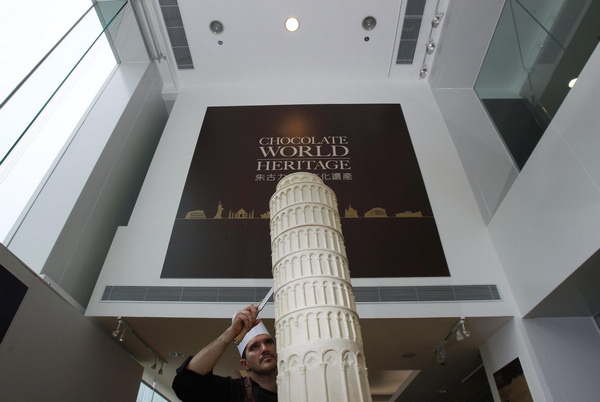 Italian chocolatier Mirco Della Vecchia puts the finishing touches on a chocolate sculpture of the Torre pendente di Pisa as part of his &apos;Chocolate World Heritage&apos; exhibition in Hong Kong Jan 20, 2011. [China Daily/Agencies]